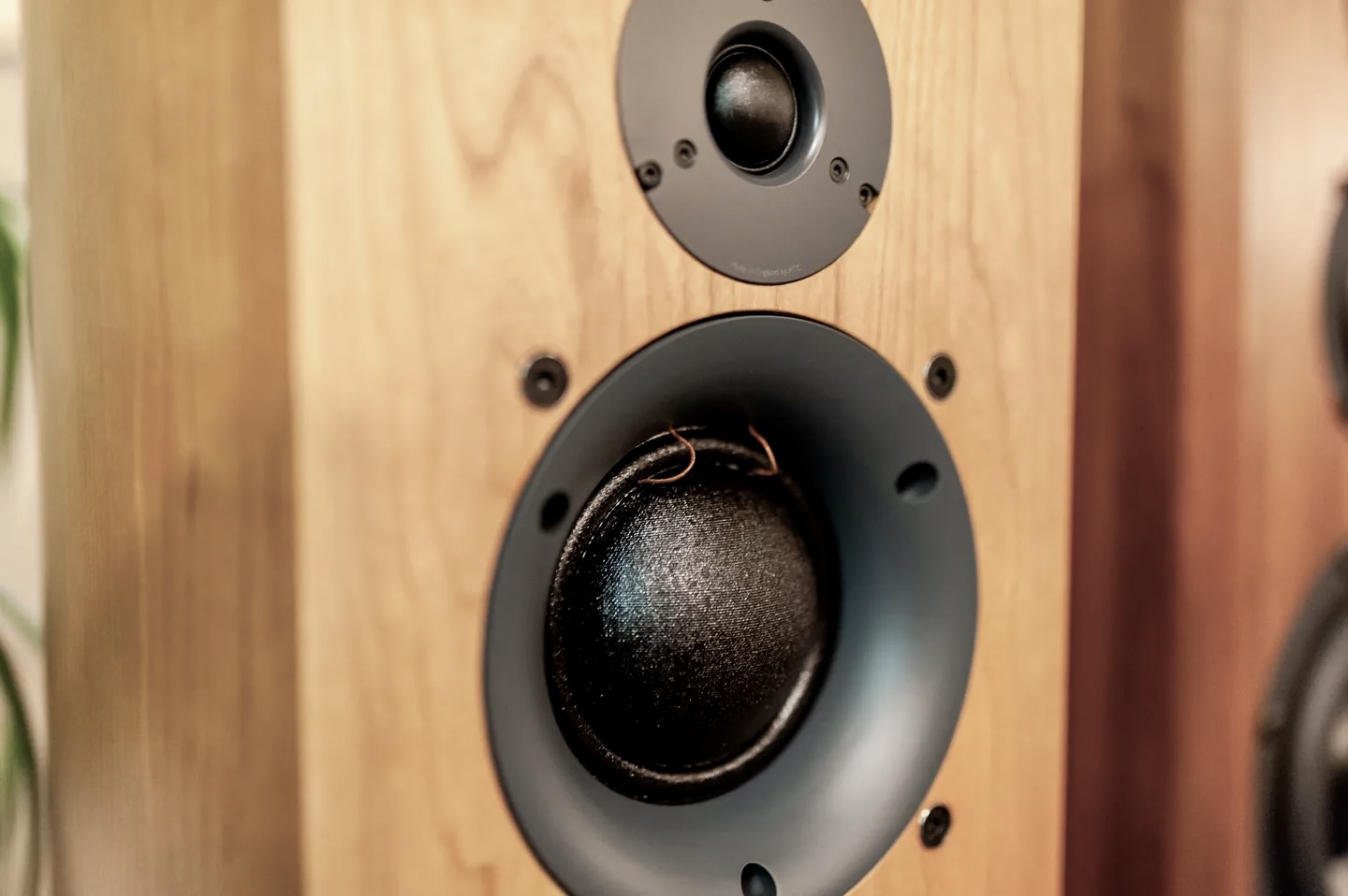 A speaker that is on top of a wooden stand.