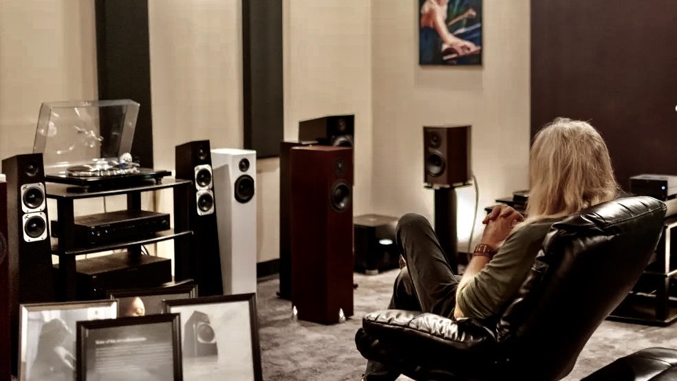 A man sitting in front of some speakers