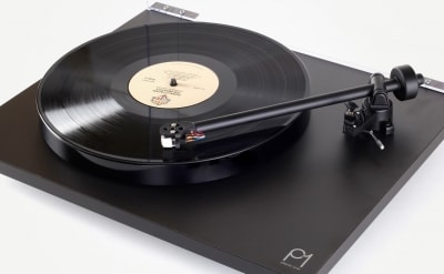 A record player with the lid open and its arm extended.